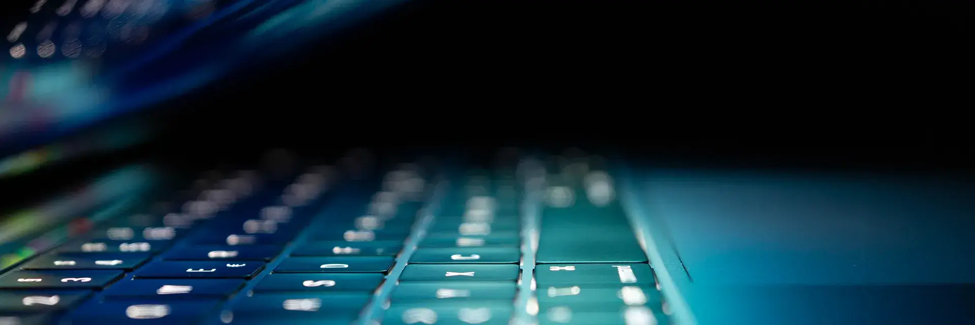 Laptop keyboard lit by the laptop screen screen in a dark room